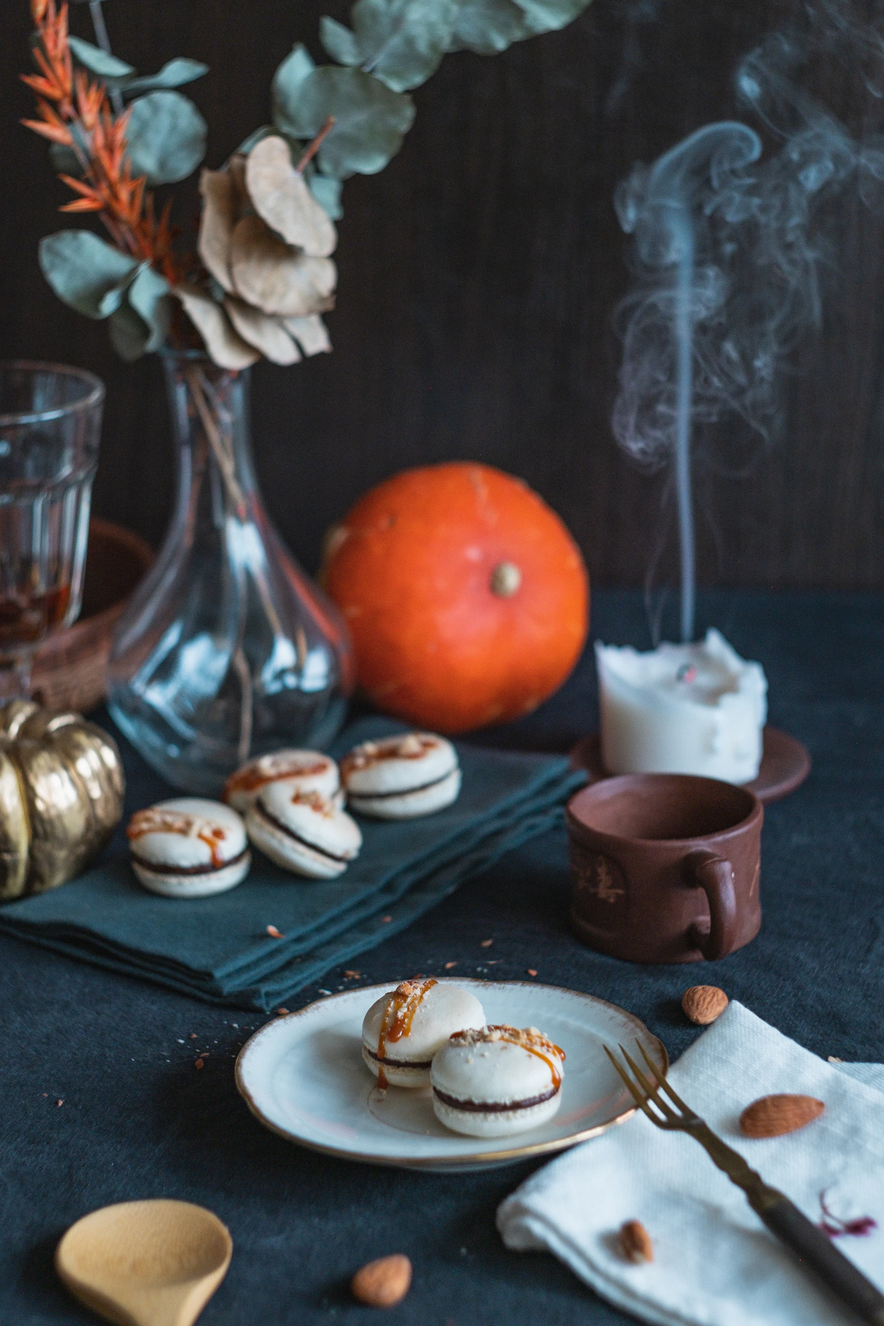 A plate of filled macarons on a dark table